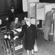A polling station at Holloway County School, Camden Road, London, where a woman is voting by proxy for her husband stationed overseas in the 1945 election.
